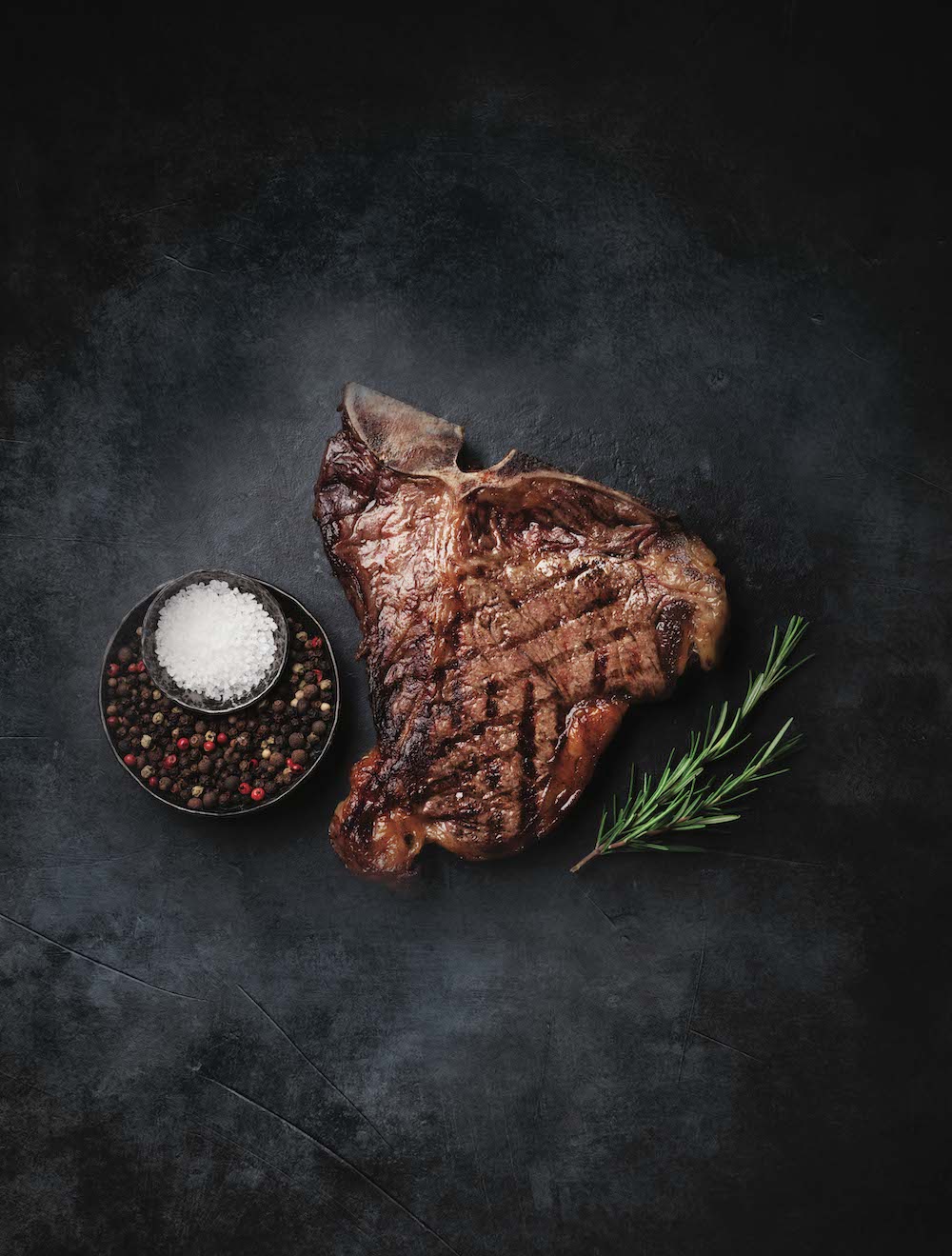 Gegrilltes T-Bone-Steak mit Grillmuster auf dunklem Schiefer